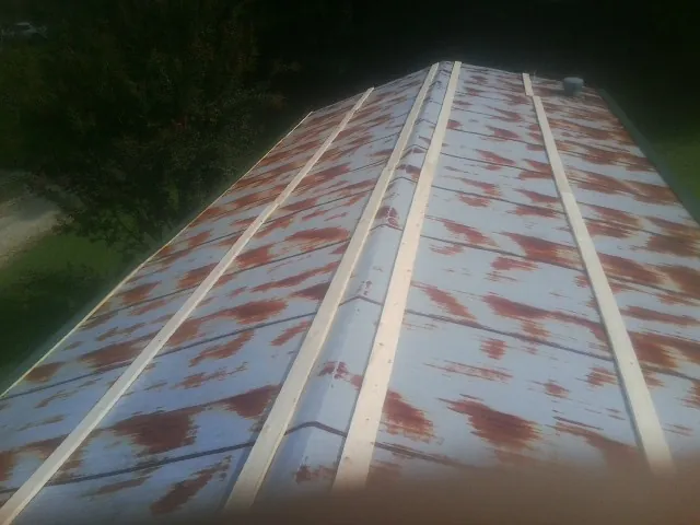 Rusted metal roof panels with new wood purlins before replacement — Storm Damage Roof Repair in Sandy Creek by Roofing Brothers