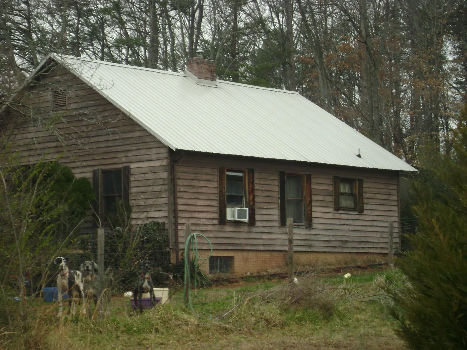 White metal roof on an old wood sided farmhouse, from a Metal Roof Installation job in Sandy Creek